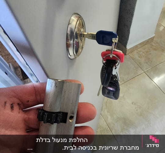 מנעול צילינדר ביד ומפתח בדלת עם מפתחות נוספים